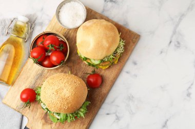 Beyaz mermer masada servis edilen vejetaryen köfteli ve sebzeli lezzetli hamburgerler. Metin için boşluk