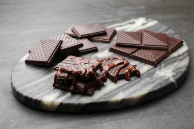 Çikolata parçaları siyah masada eriyor, yakın plan.