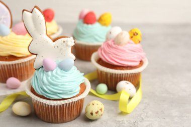 Gri masada Paskalya dekoru olan lezzetli kekler, yakın plan. Metin için boşluk