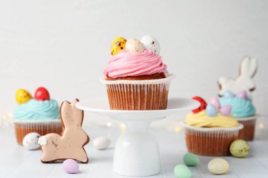 Beyaz fayanslı masada Paskalya dekoru olan lezzetli kekler, yakın plan.