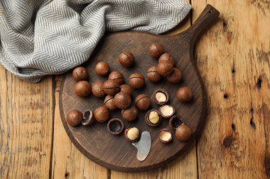 Macadamia fındıkları ve metal anahtar ahşap masada, üst manzara.