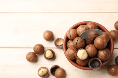 Macadamia fındığı ve metal anahtar açık ahşap masada, düz yerde. Metin için boşluk