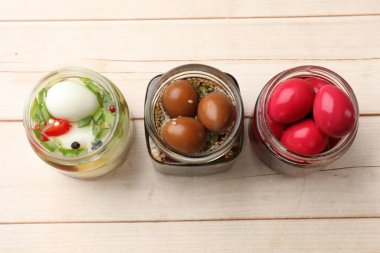 Cam kavanozlarda bıldırcın yumurtası turşusu açık ahşap masada, düz yerde.