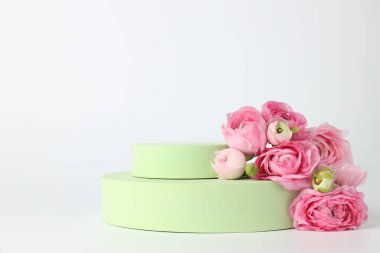 Ürün için şık bir sunum. Podyumlar ve pembe güller beyaz arka planda, yakın plan