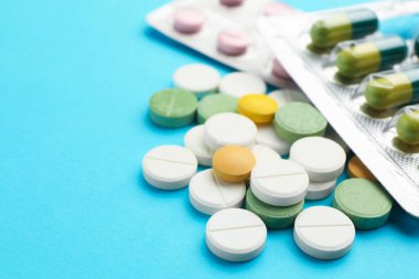 Açık mavi arka planda birçok farklı hap var, yakın plan. Metin için boşluk