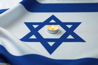 Soykırım Anma Günü. İsrail bayrağında yanan mum, yakın plan