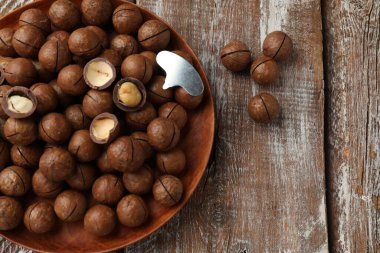 Macadamia fındıkları ve metal anahtar ahşap masada, üst manzara.