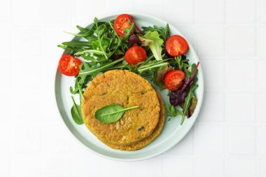 Beyaz fayanslı masada salatalı lezzetli vejetaryen köfteleri.