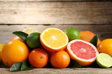 Tahta masada farklı olgun narenciye meyveleri, yakın plan. Metin için boşluk