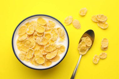 Sarı masada servis edilen sütle birlikte lezzetli mısır gevrekleri.