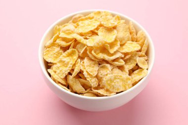 Lezzetli mısır gevrekleri pembe arka planda, yakın planda.