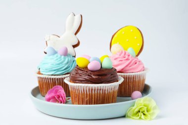 Beyaz masada Paskalya dekoru olan lezzetli kekler, yakın plan.