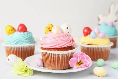 Beyaz masada Paskalya dekoru olan lezzetli kekler, yakın plan.