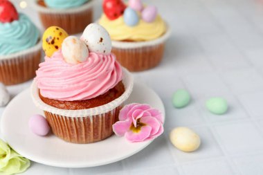 Paskalya desenli lezzetli kekler beyaz fayanslı masada, yakın plan. Metin için boşluk