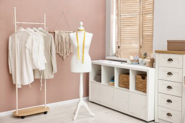 Kadın mankeni, malzeme ve mobilyaları olan şık bir atölye. İç tasarım