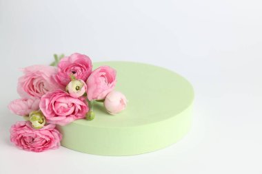 Ürün için şık bir sunum. Beyaz arkaplanda podyum ve pembe güller, yakın plan