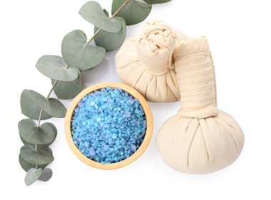 Kasede mavi deniz tuzu, bitkisel torbalar ve okaliptüs dalı beyaz, üst görünümde izole.