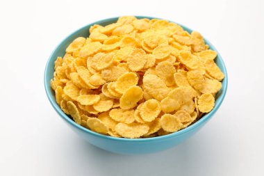 Beyaz arka planda kasede lezzetli mısır gevrekleri, yakın plan.