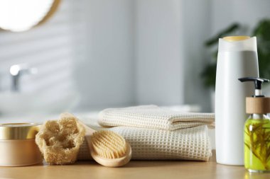 Temiz waffle havluları, kozmetik ürünleri ve kapalı masa üzerindeki tuvalet malzemeleri.