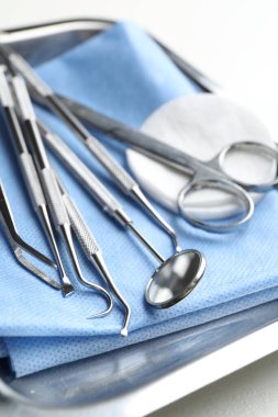 Birçok farklı diş aleti ve tıbbi peçete beyaz masanın üzerinde, yakın plan.