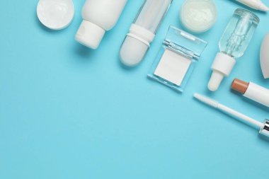 Açık mavi arka planda farklı makyaj ürünleri. Metin için boşluk