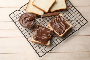Çikolata ezmeli tostlar ve tahta masada bıçak, üst manzara.