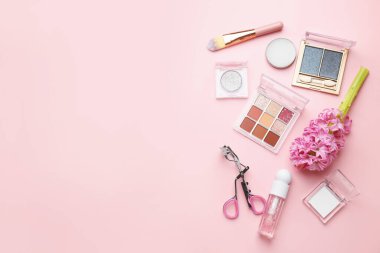 Farklı makyaj ürünleri ve pembe arka planda sümbül çiçekleri içeren bahar kompozisyonu. Metin için boşluk