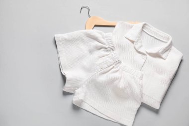 Açık gri arka planda modaya uygun beyaz pijamalar, üst manzara. Metin için boşluk