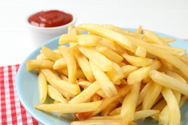 Lezzetli patates kızartması, beyaz masada ketçap, yakın plan.