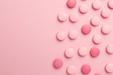Pembe arka planda farklı haplar, düz yatış. Metin için boşluk