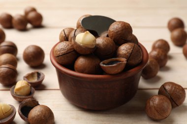 Makadamia fındığı ve metal anahtar açık tahta masada, yakın plan.