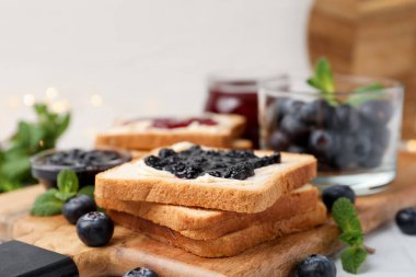 Tereyağlı tost, tatlı reçel, böğürtlen ve nane şekeri masada, yakın plan.