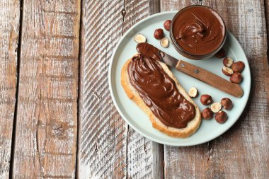Çikolata ezmeli tost, fındık ve tahta masada bıçak, üst manzara. Metin için boşluk