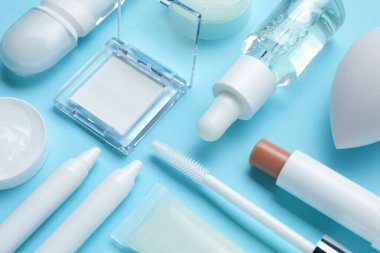 Açık mavi arkaplanda farklı makyaj ürünleri, yakın plan