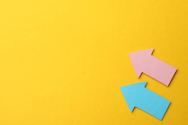 Turuncu arka planda renkli kağıt oklar, düz yatış. Metin için boşluk