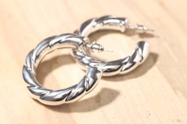 Açık arkaplanda güzel gümüş küpeler, yakın plan.