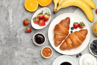 Sağlıklı kahvaltı. Lezzetli kruvasan ve böğürtlen içeren düz kompozisyon gri desenli masa. Metin için boşluk