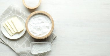 Kabartma tozu, şeker ve tereyağı beyaz ahşap masada, düz yerde. Metin için boşluk