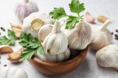 Taze sarımsak, biber ve maydanoz açık gri masada, yakın plan.