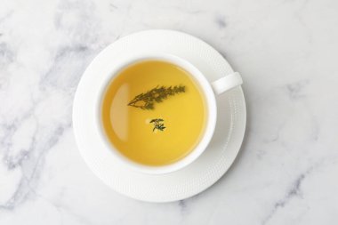 Beyaz mermer masada fincanda taze kekik çayı, üst manzara.