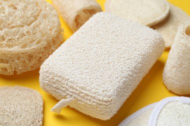 Banyo bezi ve sarı arka planda doğal lif süngeri, yakın plan.