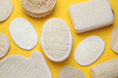 Banyo bezi, eldiven ve doğal lif süngeri sarı arka planda, düz yatıyordu.