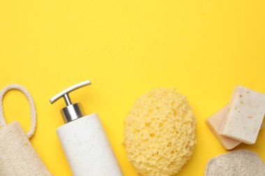 Sarı arka planda farklı banyo süngeri, sabun ve kozmetik ürünleri, düz yatak. Metin için boşluk