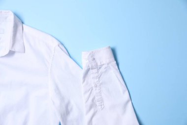 Açık mavi arka planda dağınık gömlek, üst manzara. Metin için boşluk