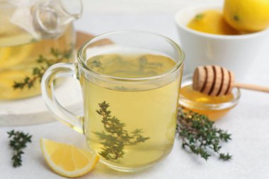 Cam bardakta taze kekik çayı, bal ve gri masada bir dilim limon, yakın plan.