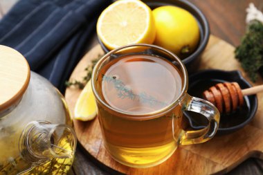 Cam bardakta Aromatik kekik çayı, çaydanlık, masada limon ve bal, yakın plan.