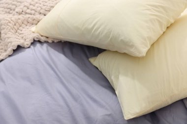 Temiz pamuklu çarşafları olan rahat bir yatak, yakın plan.