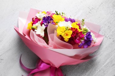 Açık arkaplanda renkli frezya çiçeklerinden oluşan güzel bir buket, üst manzara.