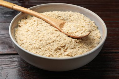 Kuru maya taneleri kasede ve kaşık tahta masada, yakın plan.