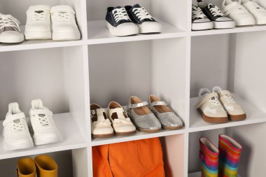 İçeride raflarda farklı stil çocuk ayakkabıları var.